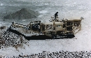 Track-Mounted Crusher goes to job site to crush stone.