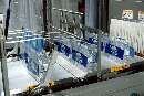 Multiwrapper stabilizes bottles throughout shrink wrapping.