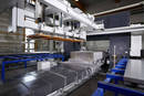 Bandsawing Machine cuts aluminium blocks horizontally.