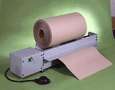 Feeder dispenses rolls of dunnage and wrapping materials.
