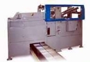 Machine unloads unstable plastic bottles from reshippers.