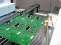 Conveyor controls PCB warpage during selective soldering.