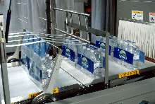 Multiwrapper stabilizes bottles throughout shrink wrapping.
